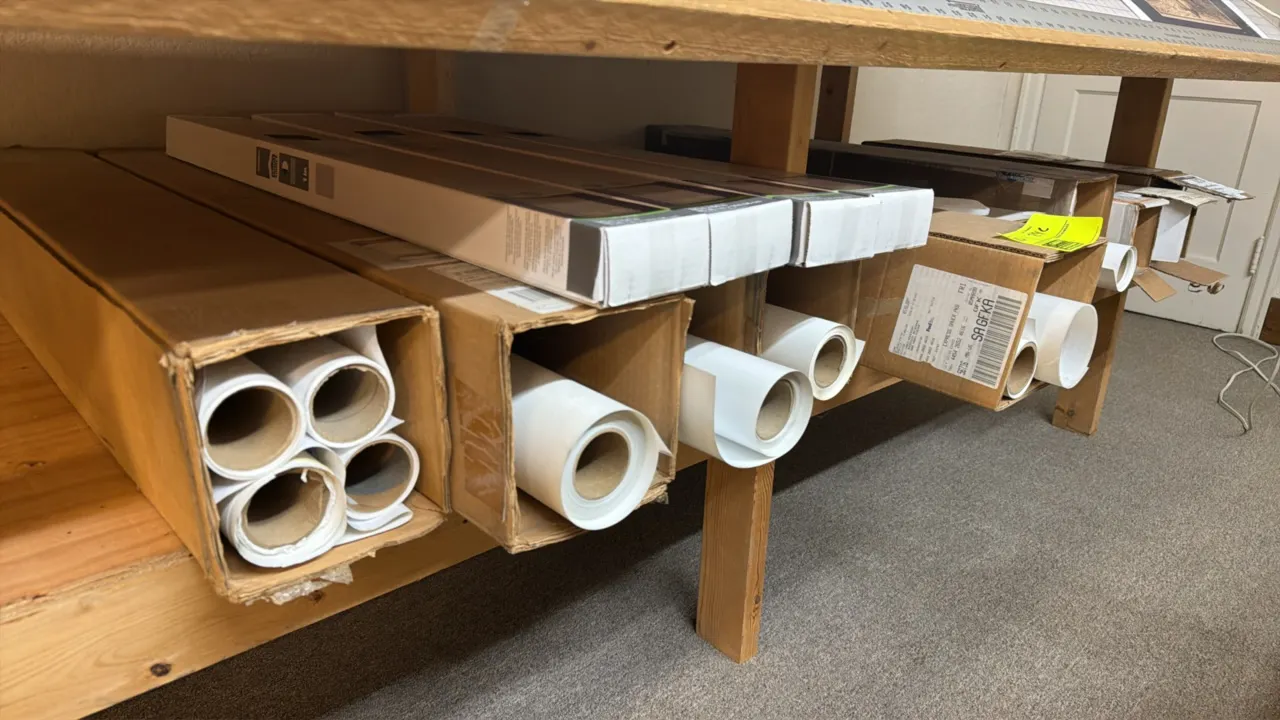 Assorted plotter paper rolls. Compatible with HP DesignJet Z6 Pro production printers. Includes an assortment of boxed and loose media rolls. Shelving