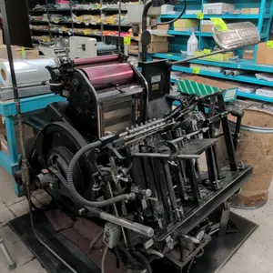 Original Heidelberg Windmill automatic sheet-fed platen letterpress. Features a 10" x 15" platen size. Includes a 30" portable metal work table on cas