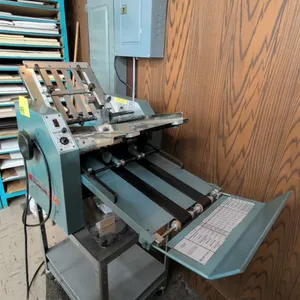 Baumfolder 714 tabletop paper folding machine. Features 14 x 20 series format, adjustable fold plates, dial controls, and discharge conveyor. Includes