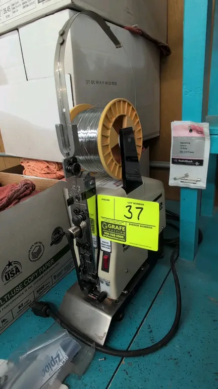 Interlake 306F table-mount wire stitching machine. Features Acme Champion stitching head, spool holder, overhead wire guide arm, and hand jog control.