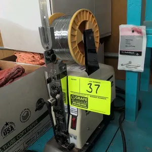 Interlake 306F table-mount wire stitching machine. Features Acme Champion stitching head, spool holder, overhead wire guide arm, and hand jog control.