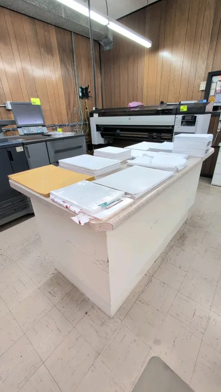 Laminate countertop work island. Features a speckled laminate top with bullnose edge and open lower storage shelf. 6'L x 3'W x 3'H. Contents not inclu