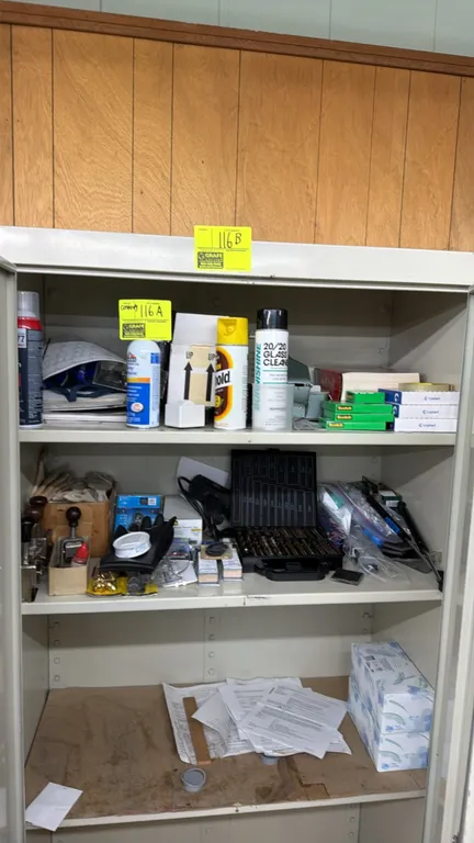 Assorted cabinet contents. Includes drill bit set in index case, metal numbering stamps, paint brushes, spray adhesives, aerosol cleaners, tape, and a
