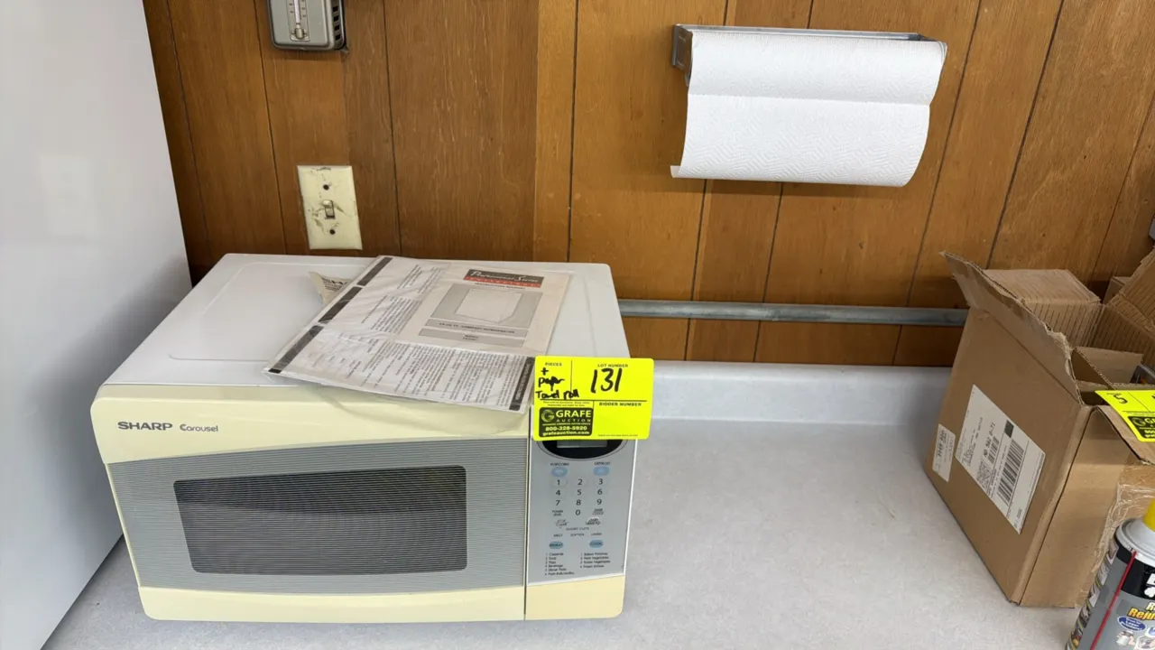 Sharp Carousel countertop microwave oven. Features digital touchpad controls, preset cooking options, and off-white front finish. Includes operation m