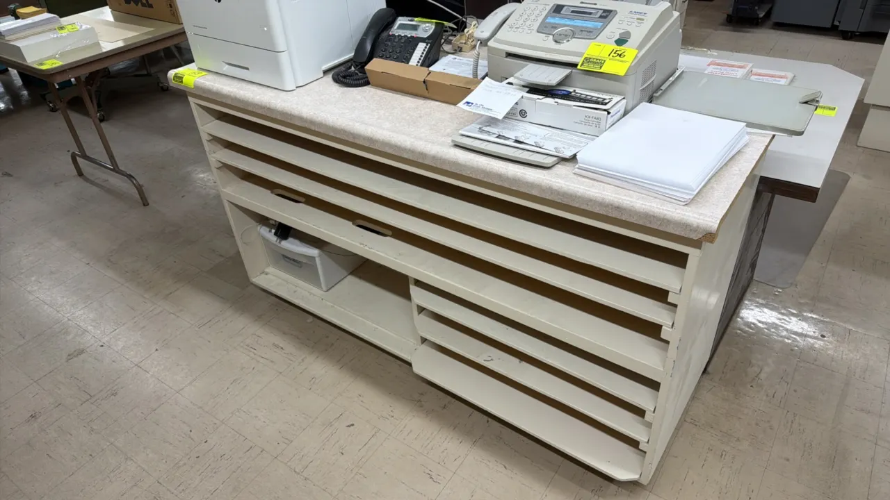 Work counter with under-counter shelving. Features a faux-stone laminate countertop, multi-tier horizontal sorting shelves, and open lower storage com