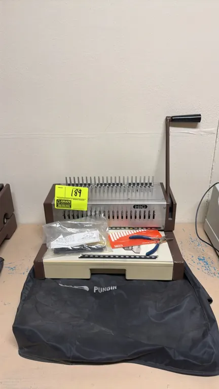 HIC Punbin manual comb binding machine. Features manual punch lever handle, comb binding fingers, and includes a protective dust cover and assorted ac