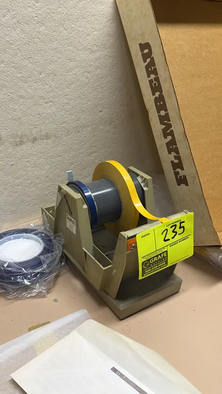 Scotch multi-roll tape dispenser. Features weighted base, multi-roll drum core, and integrated serrated cutting blade.