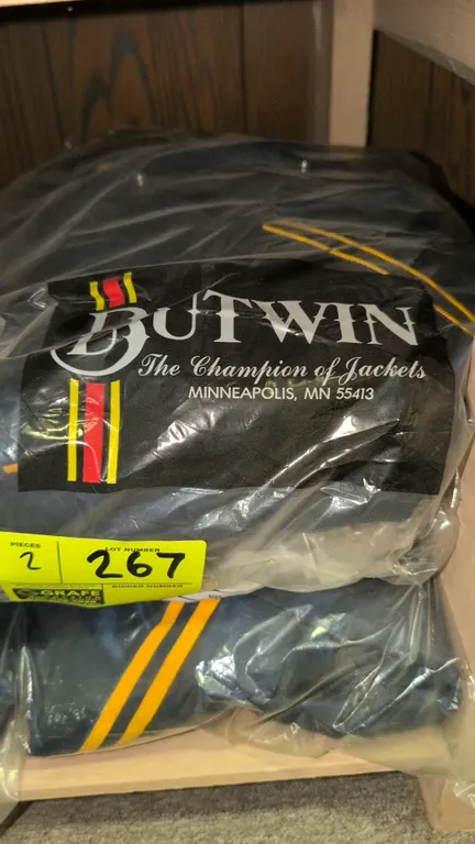 Butwin hooded nylon letterman jackets. Size XL. Features blank navy blue and gold styling, snap-button front closure, attached drawstring hood, quilte