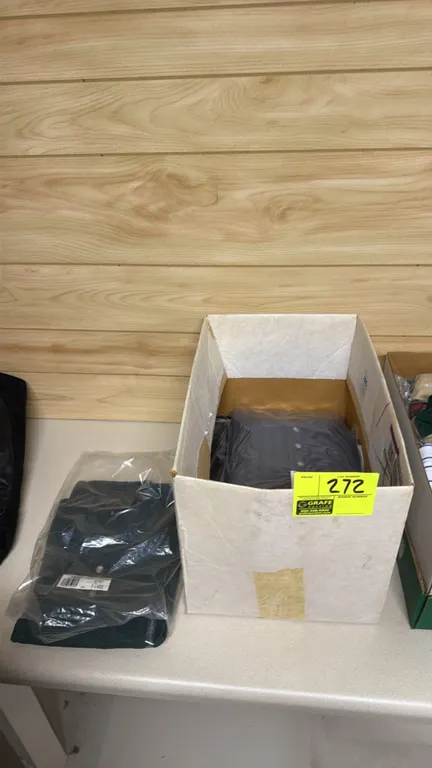 Assorted polo shirts in storage box. Includes Van Heusen and other assorted brands. Features assorted sizes.