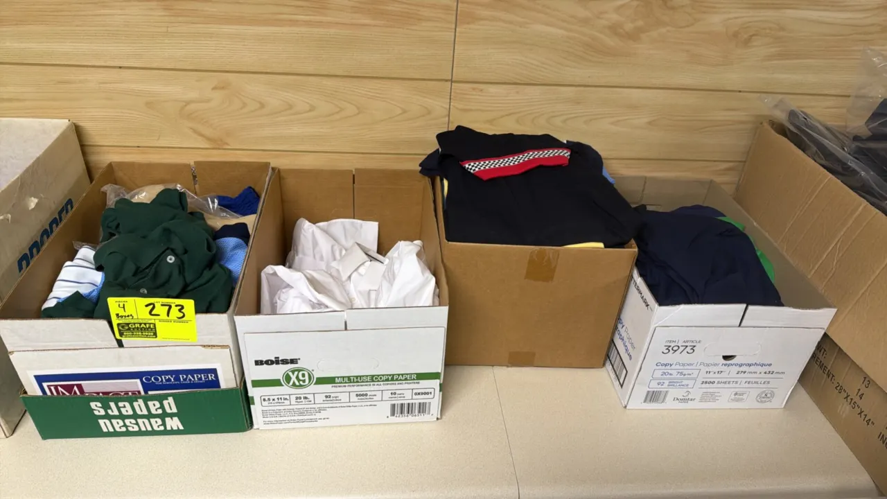 Boxes of assorted apparel. Includes T-shirts, polo shirts, and button-up dress shirts in various colors and styles. Sizes: Assorted.