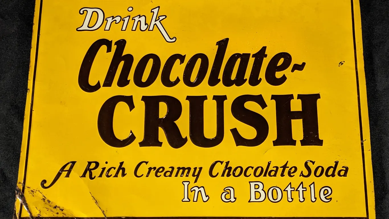 EMBOSSED TIN SIGN DRINK CHOCOLATE CRUSH IN A BOTTLE