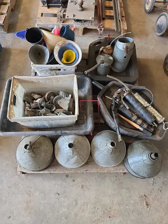 Large quantity of funnels, oil cans, oil pans, grease guns and caster wheels