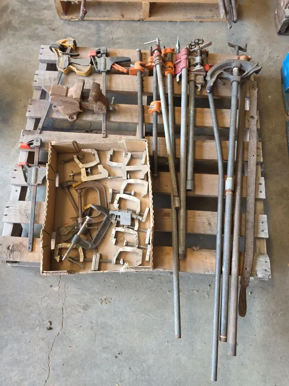 Pallet of assorted clamps and small bench vice