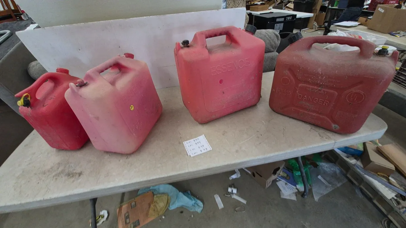 Four Red Plastic Gas Cans, One “ESSENCE” Brand