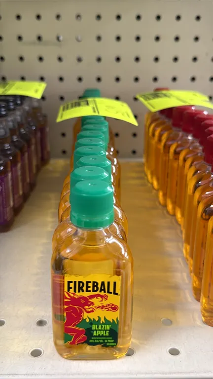 Fireball Blazin' Apple whisky 50ml bottles. Features flavored whisky with natural flavors, 33% ALC/VOL (66 Proof), and green screw-top caps. Liquor ca