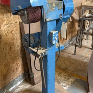 6" buffer and flap wheel sander. Features a belt-driven electric motor, protective wheel hood, mesh belt guard, and column-mounted toggle switch. Moun