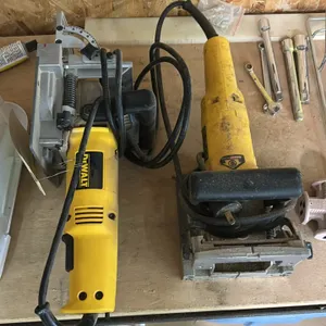 DeWalt DW682 plate and biscuit joiners. Features adjustable fence, top handle, and corded electric power. Background tools not included.
