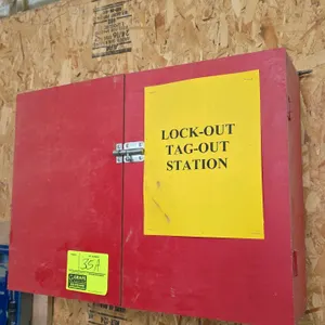 Wood lockout tagout station cabinet. Features double hinged doors with latch closure, red painted exterior, and interior storage hooks. Includes assor