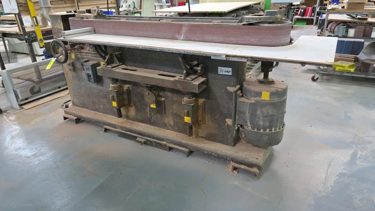 Curtis 91-6 horizontal belt sander. Features a 175" x 6" sanding belt, work support table, dust collection port, rear belt storage rack with spare bel