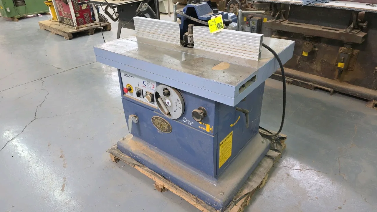 2006 Oliver 14-4750 002 heavy-duty wood shaper. Features 5.5 HP motor, 5-speed reversible spindle operation, adjustable fence assembly, miter attachme