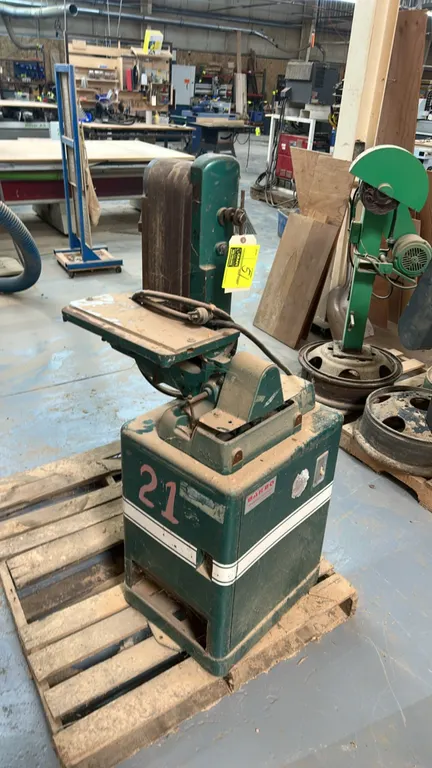Barbo belt sander. Features a vertical belt configuration, adjustable work support table, and integrated toggle power switch. Mounted on an enclosed m