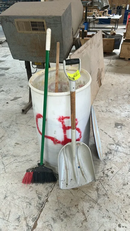 Poly scoop shovel and poly broom. Shovel features a poly blade, wooden shaft, and D-handle grip. Broom features an angled head with synthetic bristles