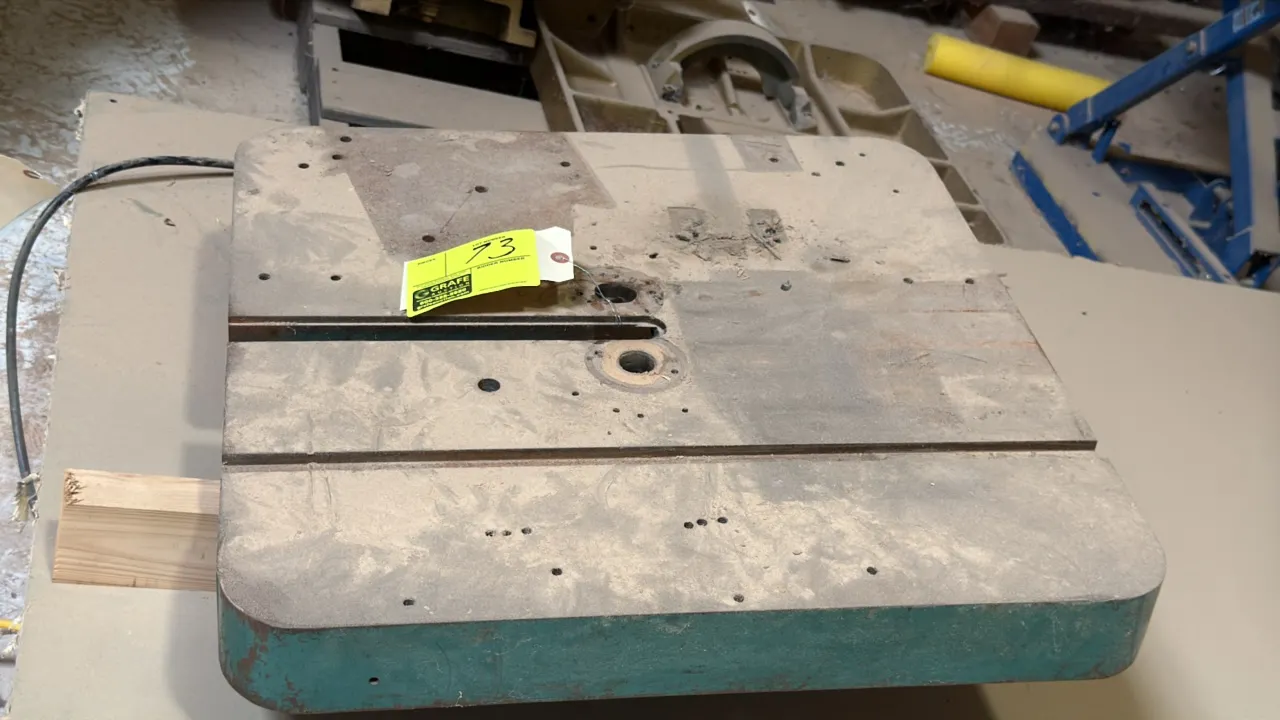 Grizzly Industrial bandsaw table. Features cast iron construction with miter gauge slot and blade slot opening. Green finish.