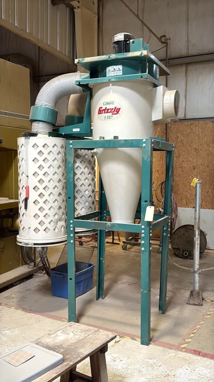 Grizzly Industrial G0601 cyclone dust collector. Features a 5 HP motor, 10" inlet, 16" impeller, dual cartridge canister filters, and cyclone separato