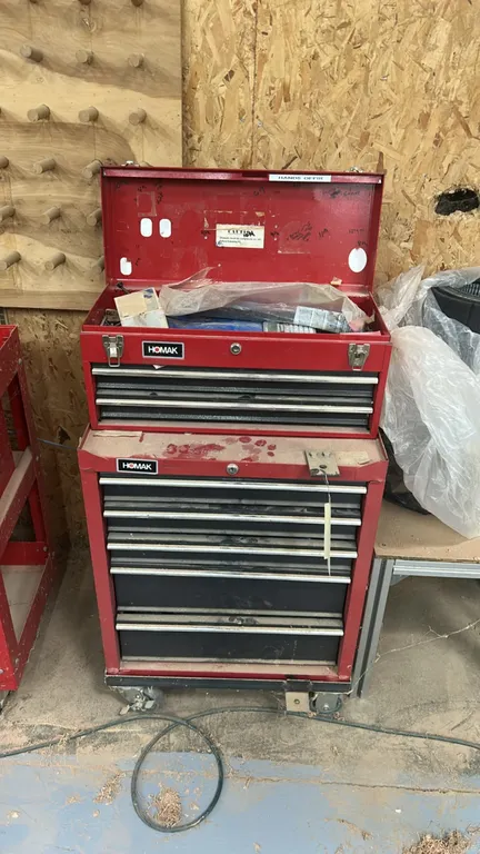 Homak metal rolling tool chest combo. Includes top chest and bottom cabinet with multi-drawer storage. Includes assorted wrenches, nuts, bolts, and re