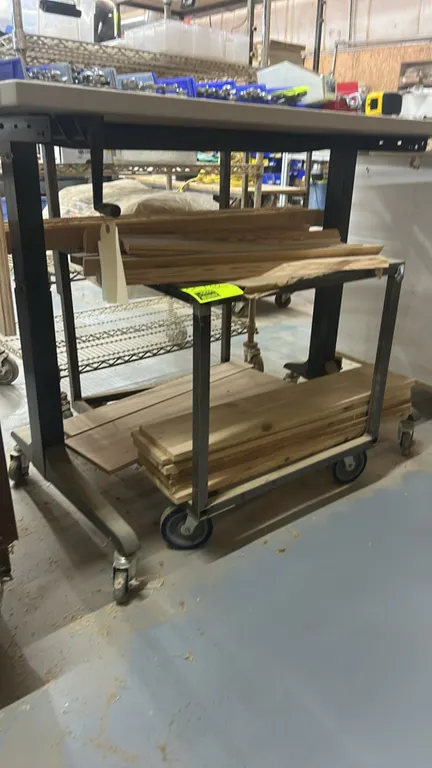 Metal 2-tier utility cart. Includes an assortment of wood boards. 24" x 27". Mounted on casters. Desk overhead not included.