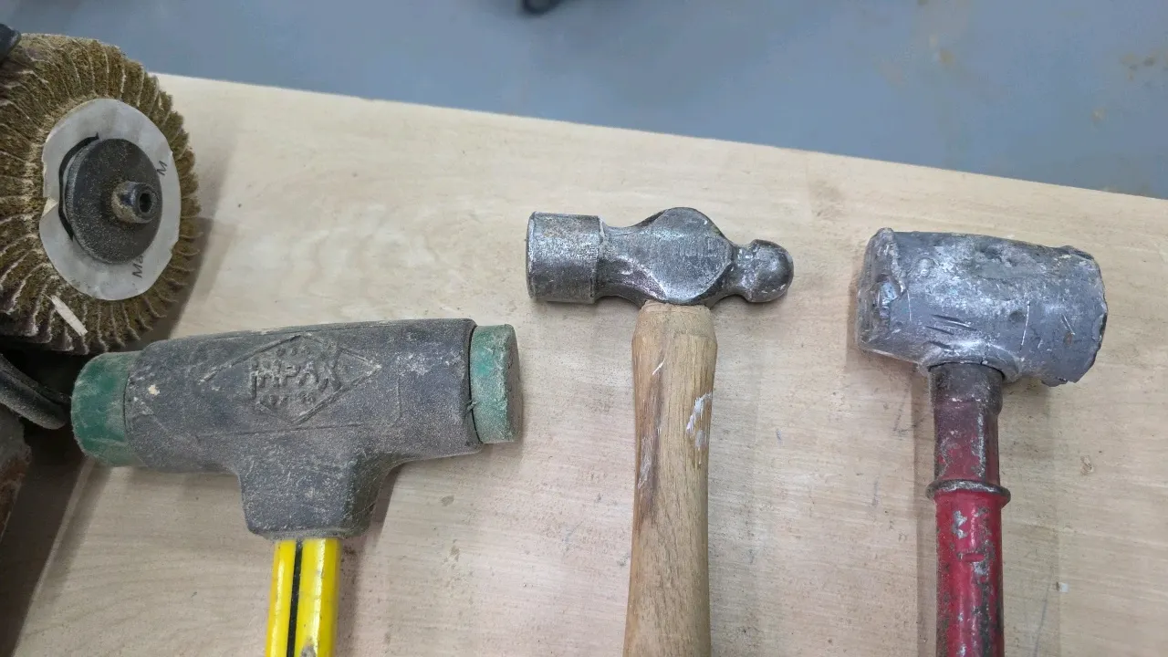 Assorted hammers. Includes Nupla soft-face mallet with fiberglass handle, ball-peen hammer with wood handle, and metal hammer. Note: One hammer head i