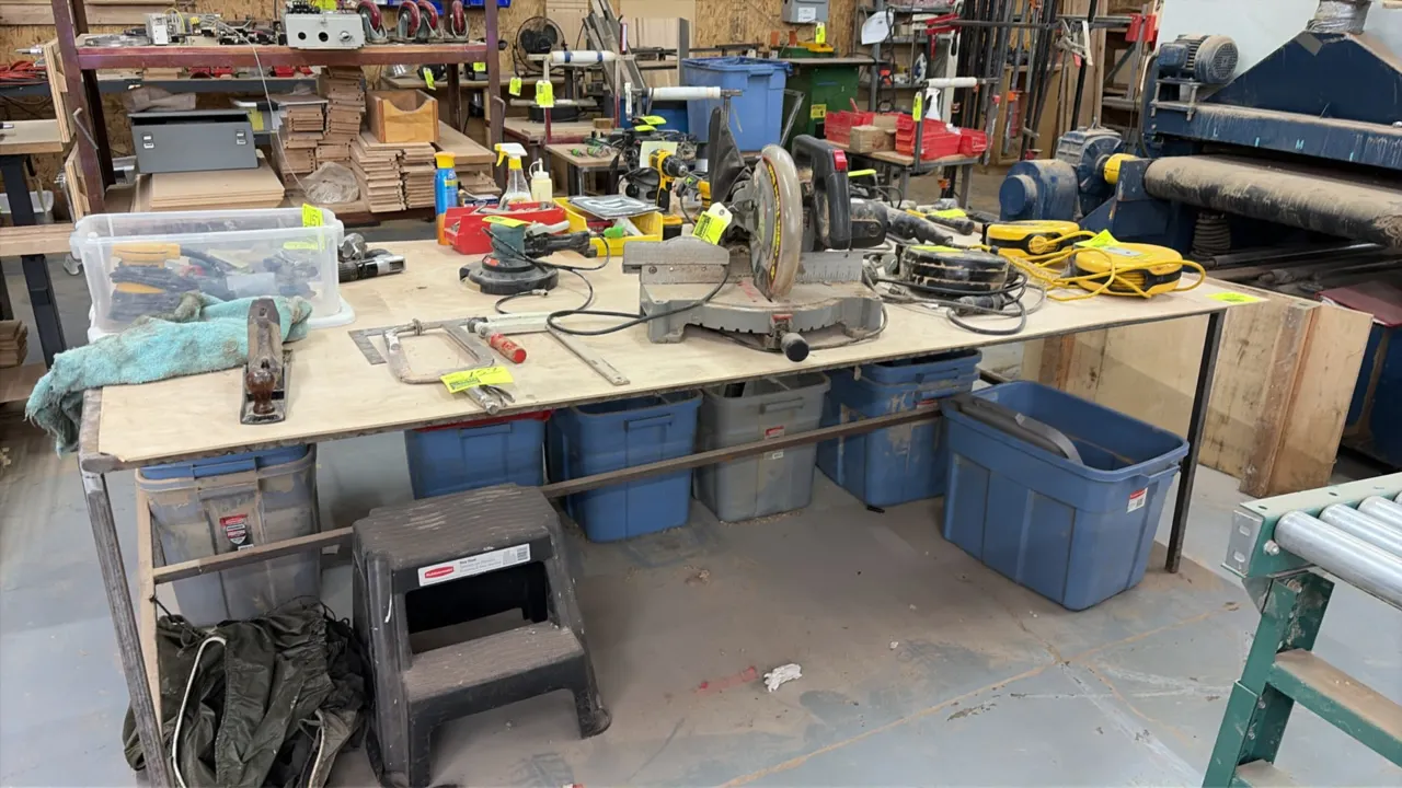 Wood top work table. Features a plywood top mounted on a square-tube metal frame base. 8' x 4'. Note: Tools and contents shown on and around table are