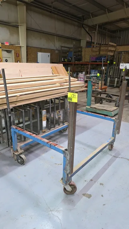Industrial metal material handling cart. Features open steel tube frame construction with vertical support uprights. 53"W. Mounted on casters.