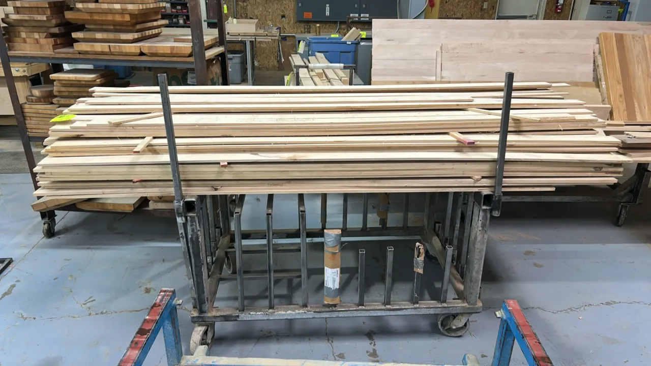 Assorted wood lumber with mobile metal cart. Features approx. 8' x 5/16" assorted wood boards. Metal rack measures 54" x 32" and is mounted on casters