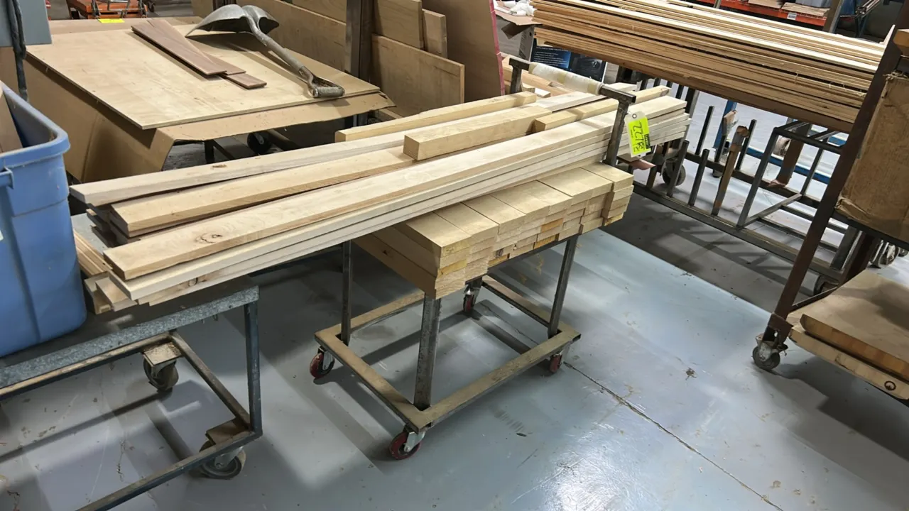Metal utility cart with quantity of assorted wood lumber. 31". Features a tubular steel frame with push handle. Mounted on swivel casters.