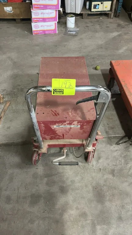 ULINE manual hydraulic scissor lift table cart. Features foot pump operation, hand release lever, chrome push handle, and steel platform. 44"L. Mounte