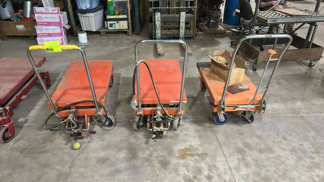 ULINE manual hydraulic lift table carts. Features foot pedal operation, scissor lift mechanism, and tubular push handle. 44"L. Mounted on casters. Box