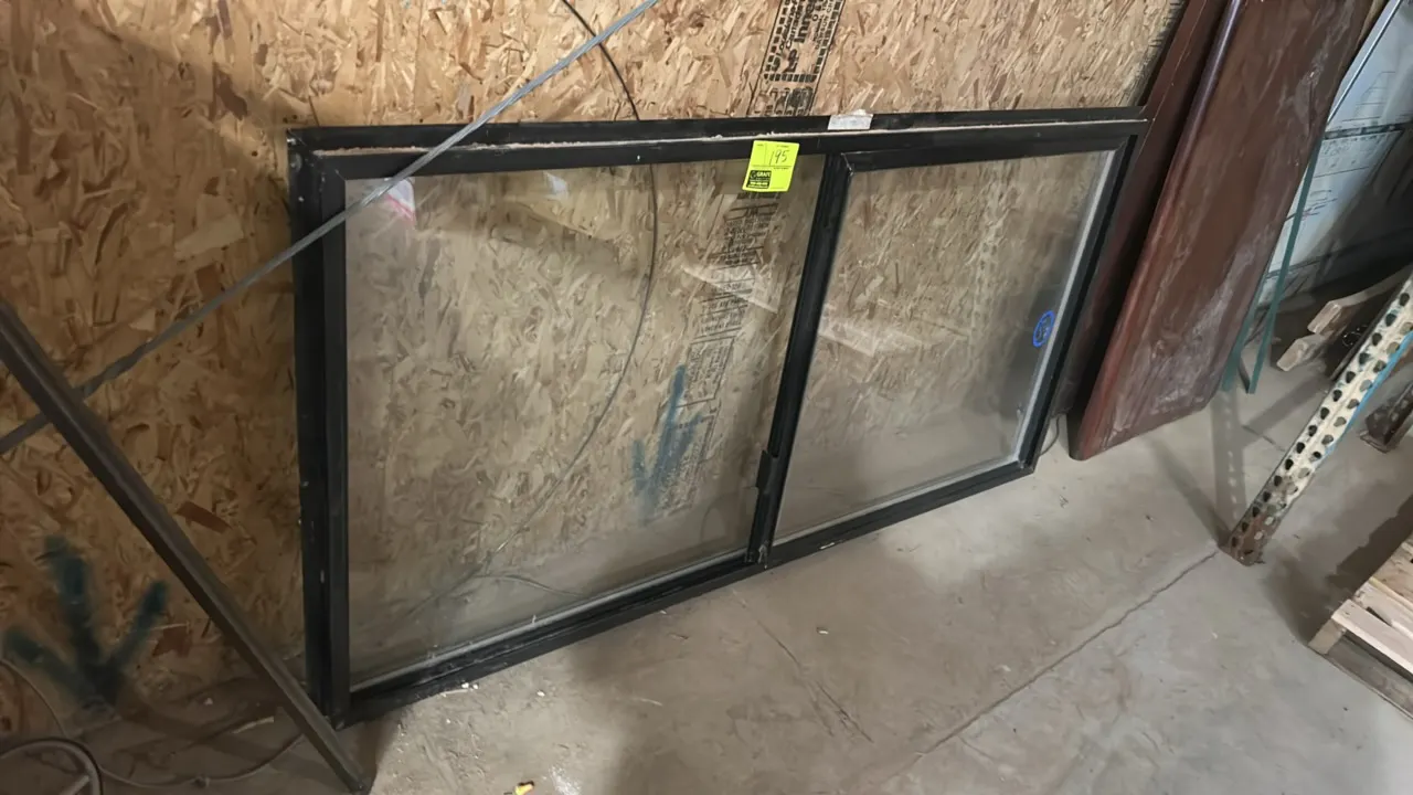 Single-pane sliding glass window. Features a black frame and horizontal sliding sash. 68"W x 36"H.