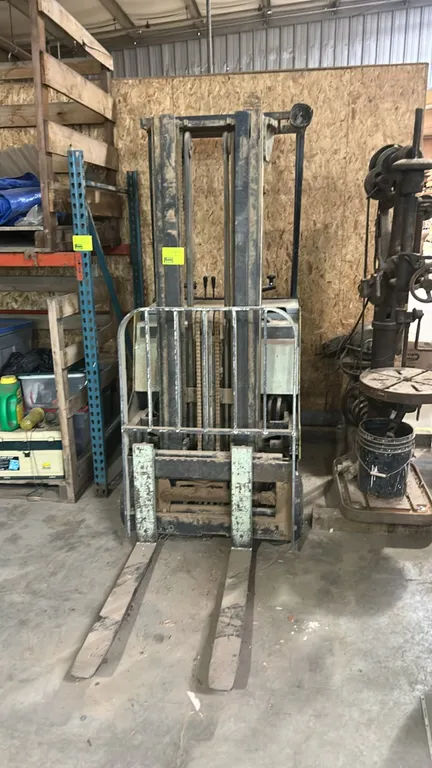 Yale electric stand-up rider counterbalance forklift. Features forks, load backrest, overhead guard, and an EnerSys 125G-15 24V battery. Note: Unteste