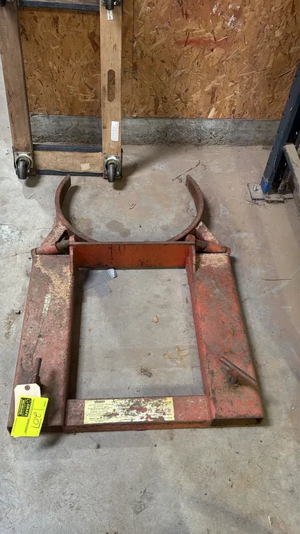 Wesco forklift drum grabber attachment. 1,500 lb capacity. Features steel construction, hinged mechanical drum clamping jaws, and dual fork pockets wi