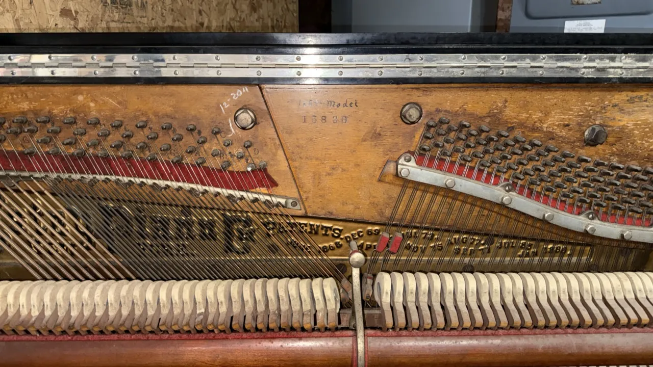 Estey Piano Co. 1889 Model Cabinet Grand upright piano. Features black finish, ornate decorative carved lattice panels, spiral-turned front legs, cast