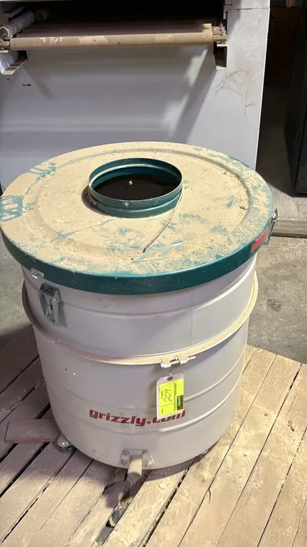 Grizzly portable metal dust collector collection drum. Features latching removable lid with top collar connection port and lower fitting. Mounted on c