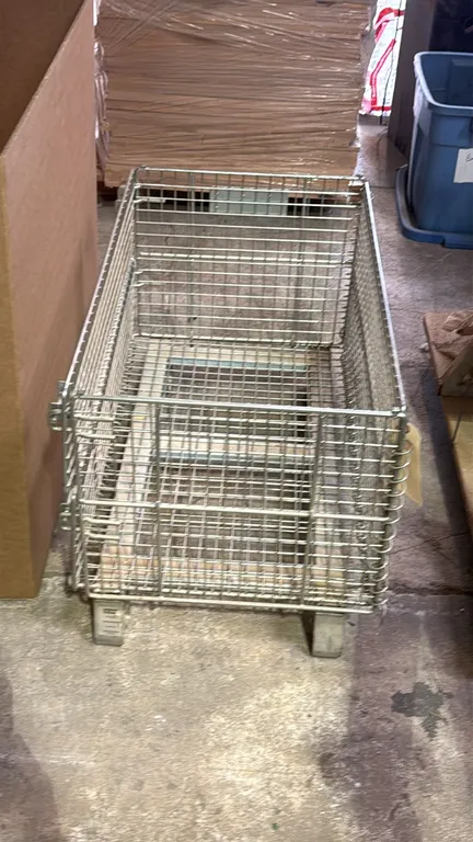 Uline metal wire basket. Features collapsible wire mesh construction, front drop gate with latches, and raised metal feet. 33" x 19" x 21".