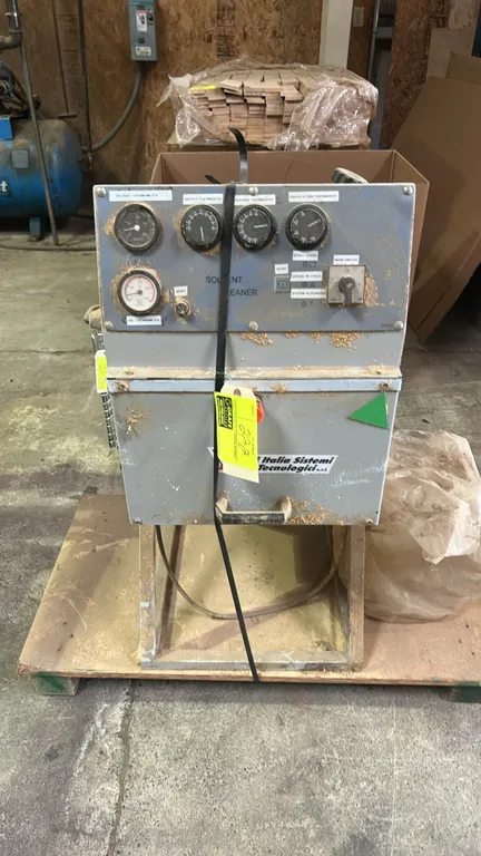 2005 I.S.T. IST 10 solvent recovery system. Features a top-loading clamped lid, analog temperature gauges, thermostat controls, and tilting pivot stan
