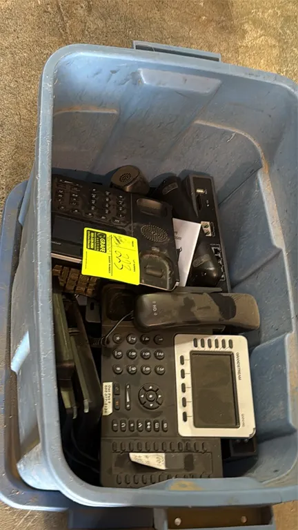 Office electronics package lot. Includes a Staples 15-sheet paper shredder and a blue plastic storage tote with lid containing assorted office desk ph