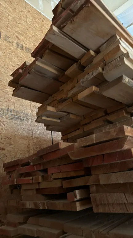 Skid of assorted wood boards. Features rough-cut lumber in varied widths with 1.25" to 1.5" thickness. Skid measures approximately 9' x 3'5" x 3'4"H.