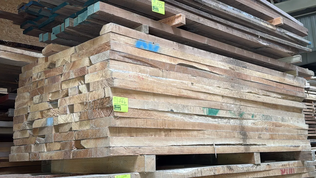 Skid of assorted wood lumber boards. Features 2" thick boards. Overall stack measures approx. 8'L x 3'6"W x 2'H.