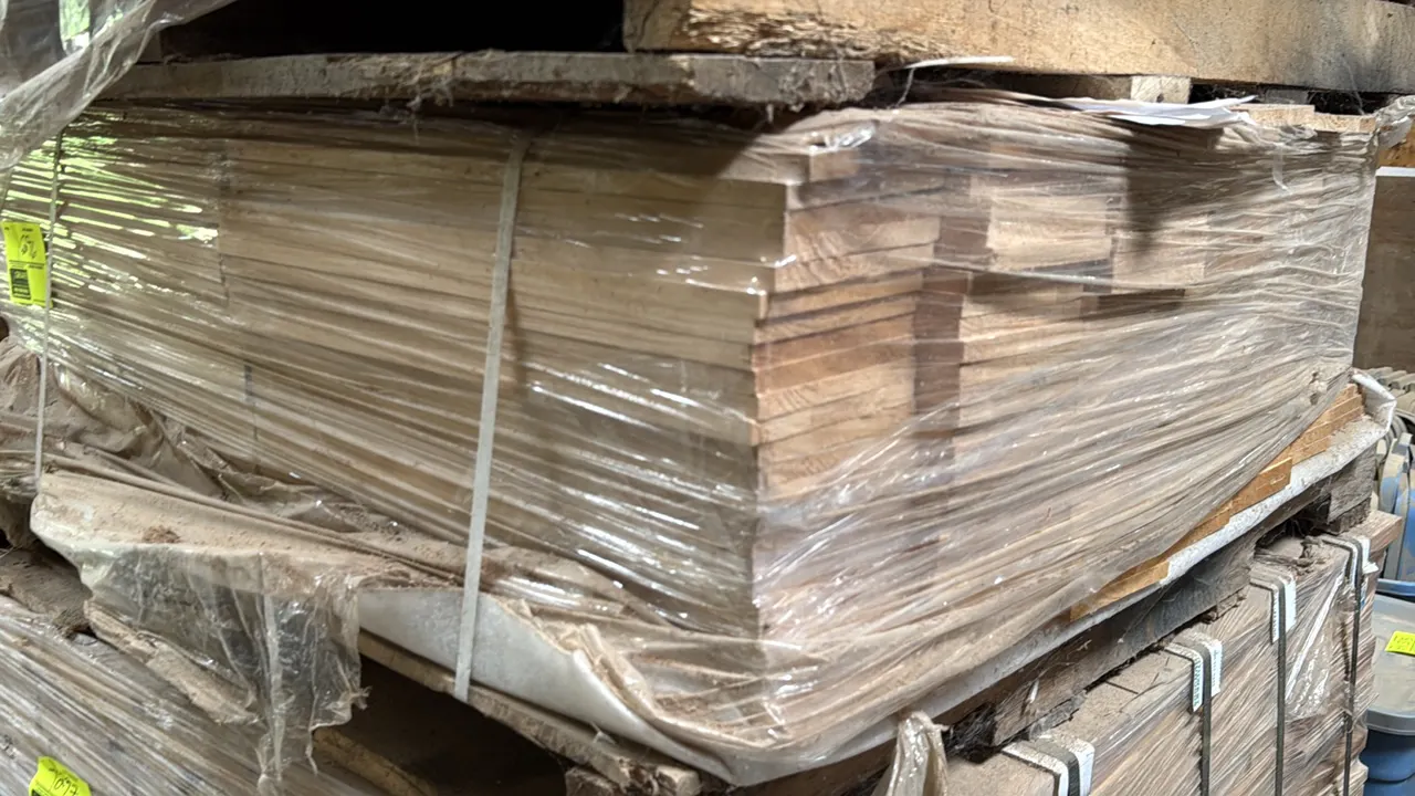 Pallet of cut wood stock boards. Individual boards measure 19" x 6" x 0.5". Shrink-wrapped and strapped on a wooden pallet.