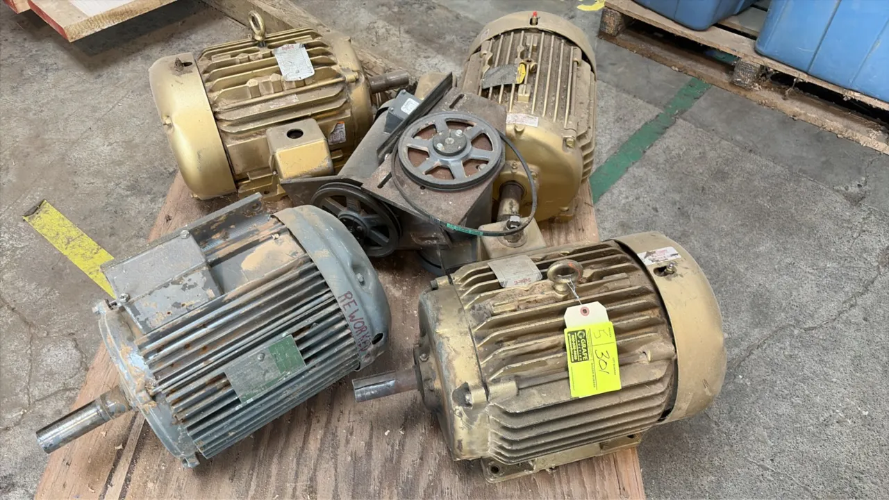 Assorted electric motors including Baldor Super-E industrial motors (including Cat. No. EM2333T, 15 HP, 230/460V, 3-Phase). Includes pulley/drive asse
