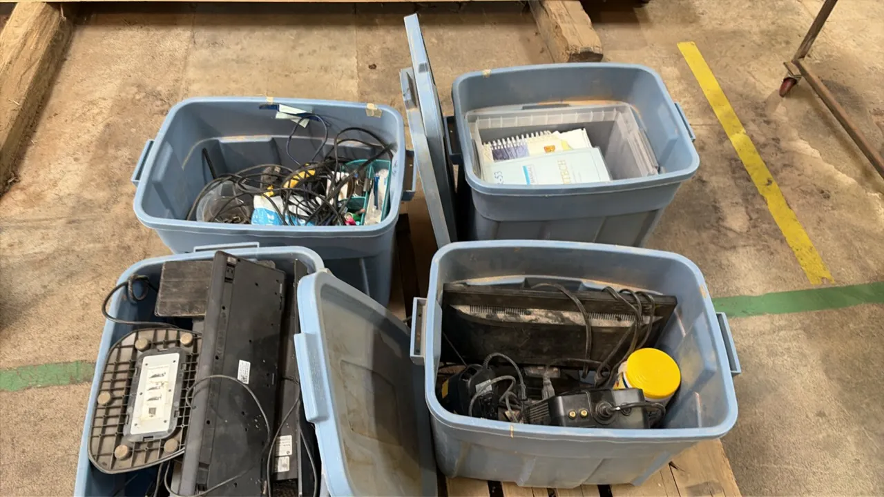 Lot of (4) plastic storage totes with computer accessories and equipment. Includes monitors, keyboards, power supplies, cables, instruction manuals, a